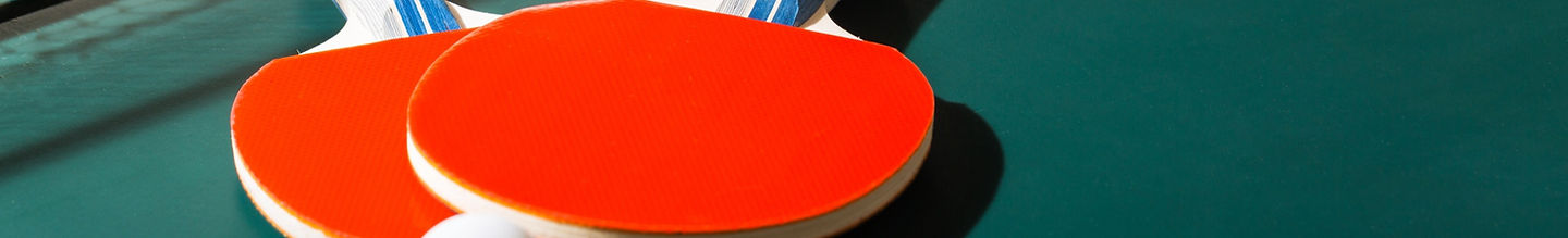 Close-up of a red table tennis table with white net and edge lines